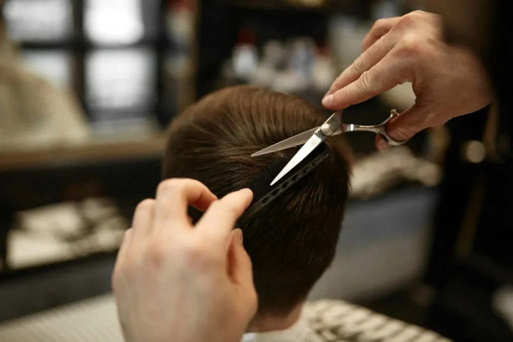 Barber trimming boy's short brown hair