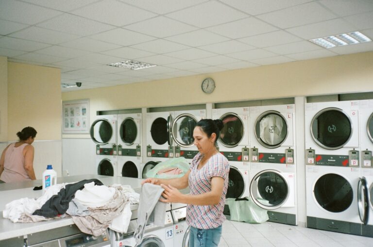 a lady folding clothes in a laundromat